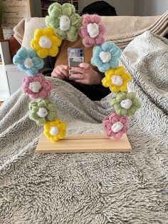 a person laying in bed taking a photo with their cell phone and flowers on the frame