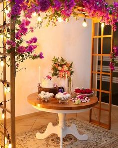 a table with flowers and candles on it in the middle of a room filled with lights