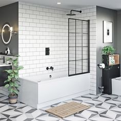 a bathroom with black and white tiles on the floor, tub, toilet and sink