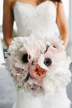 a bridal bouquet with white and pink flowers on the bride's wedding day