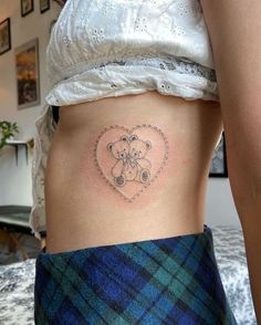 a woman with a teddy bear tattoo on her stomach