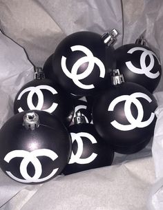 black and white ornaments with the letter g on them are sitting in a pile together