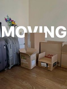 moving boxes and suitcases sitting on the floor in front of a wall that says moving