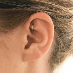 a woman's left ear is shown with a single piercing