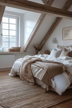 an attic bedroom with white walls and wood beams