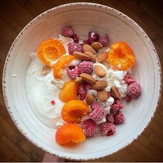 a bowl filled with yogurt, fruit and nuts