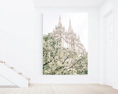 an empty room with stairs and a large painting hanging on the wall in front of it