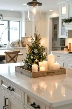 a christmas tree is on top of a kitchen counter with candles in front of it