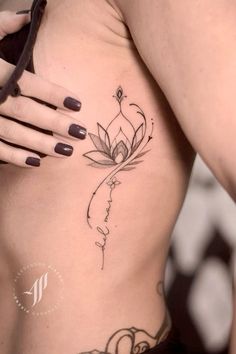 a woman's stomach with a lotus tattoo on it and the word love written in cursive writing