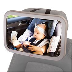 a baby in a car seat is reflected in the rear view mirror