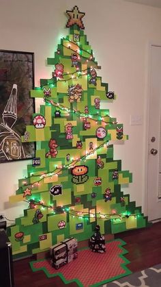 a christmas tree made out of legos in a living room with pictures on the wall