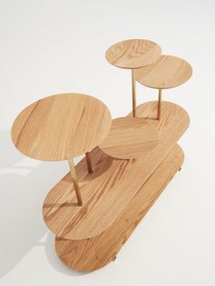 three wooden tables sitting on top of each other in the middle of a white floor