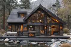 a log cabin is lit up at night on the water's edge with rocks and trees surrounding it