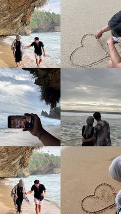 two people are walking on the beach and one is holding a cell phone in the shape of a heart