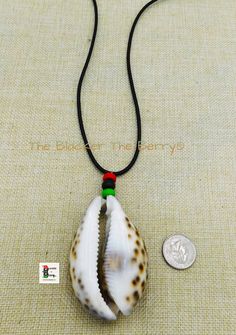 A large cowrie shell necklace will be the show stopper wherever you go. The necklace is beaded with a wooden red, black and green beads. The large cowrie shell approximately 3 inches long and 2 inches wide. The necklace is 22 inches long and it closes with a clasp. The beads are approximately 10mm. A large piece but not too heavy. If you have any questions please feel free to contact us at anytime. All shipping options are available. All items will be shipped out Monday through Friday. Receipts Black Artisan Necklaces For Beach, Black Artisan Necklace For Beach, Artisan Black Necklace For Beach, Artisan Black Jewelry For The Beach, Traditional Black Necklaces For Beach, Traditional Black Necklaces For The Beach, Cowrie Shell Jewelry, Cowrie Shell Necklace, Necklace African