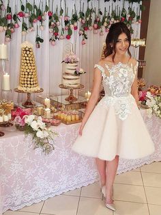 a woman standing in front of a table filled with cakes and desserts