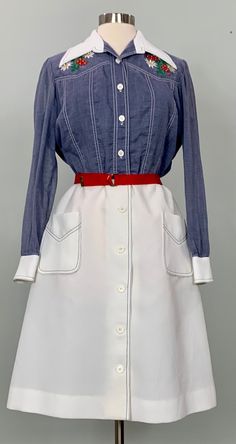 "B E S T  F I T S  Suggested Size: 8/10  Please check measurements below to ensure the best possible fit.    D  E  S  C  R I  P  T  I  O  N    *White and blue casual shirtdress  *Solid and floral embroidery on front  *Two front pockets with navy blue stitching  *Butterfly collar  *Buttons up front with hook and eye at waist  *Belt loops but no belt  *Long sleeves are somewhat sheer and have buttons at cuff  *Below the knee length  *A-line construction  *1970s era    D  E  T  A  I  L  S    * Fabr White Retro Knee-length Vintage Dress, White Retro Vintage Knee-length Dress, Fitted Retro Button-up Vintage Dress, Fitted Long Sleeve Cotton Vintage Dress, Retro Fitted Button-up Vintage Dress, White Retro Dress With Button Closure, 1970s Style Long Sleeve Vintage Summer Dress, White Long Sleeve Cotton Vintage Dress, White Cotton Long Sleeve Vintage Dress