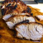 some meat is sitting on a cutting board with a knife next to it that has been cut into pieces