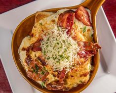 a wooden spoon filled with food on top of a white plate