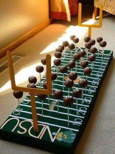 an arrangement of chocolate candies arranged on a football field in the middle of a room