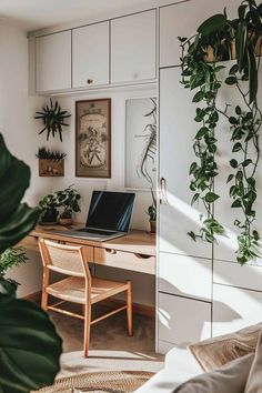 a desk with a laptop on it in front of some plants