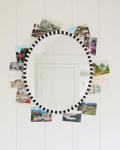 a circular mirror with pictures on it hanging from the side of a white wall next to a door