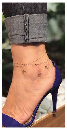 a woman's foot with a small tattoo on the side of her ankle and an arrow