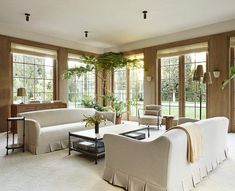 a living room filled with white furniture and lots of windows next to eachother