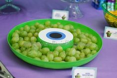 grapes in a green bowl on a purple tablecloth with place cards and silverware