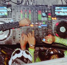 two people are touching the controls on a dj's equipment set up in front of them