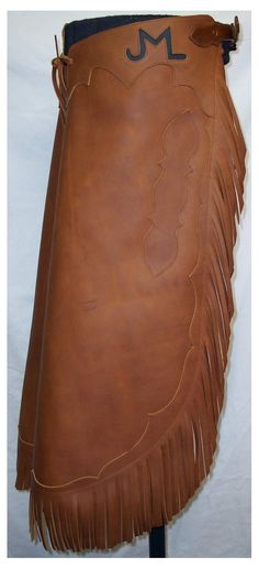 a brown leather skirt with fringes on the bottom and one side that says j m