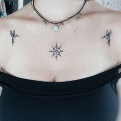 a woman with tattoos on her chest is wearing a black top and has a star tattoo