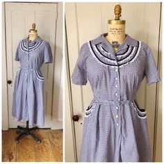 This pretty dress features an overall gingham pattern in shades of navy blue & white. There are short sleeves & little lace ruffle details throughout. There are button front closures & pockets at the sides. Matching belt. This would best fit a size large. **FYI: the dress is pinned to my dress form in the photos. Please see measurements to ensure a proper fit.** Condition: some extra threads here & there. Measurements: Bust: 42 inches Waist: 34.5 inches Hip: 48.5 inches Shoulder to shoulder: 15 inches Sleeve length: 10 inches  Bodice: 18 inches Length (shoulder to hem): 42 inches Label: N/A Classic Short Sleeve Gingham Dress, Classic Gingham Short Sleeve Dress, Vintage Gingham Dress With Short Sleeves, Classic Gingham Dress With Short Sleeves, Navy Vintage Short Sleeve Dress, Fitted Gingham Vintage Cotton Dress, Fitted Cotton Gingham Vintage Dress, 1950s Gingham Cotton Dresses, Vintage Gingham Cotton Dress