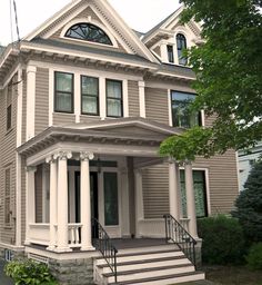 a large gray house with white trim and windows