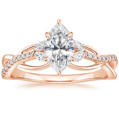 a rose gold engagement ring with a pear shaped diamond in the center and side stones