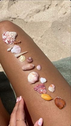 a woman's legs with seashells and shells on the side of her leg