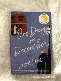 the book one day in december by jose silver is laying on a white fluffy surface