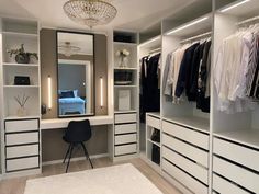 an organized closet with white drawers and black accents, including a chandelier hanging from the ceiling