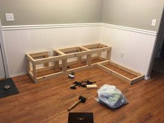 a laptop computer sitting on top of a hard wood floor next to some construction materials