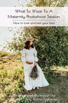 A pregnant woman stands in a field in a long, flowy, white, boho dress with long sleeves, holding a bouquet of wildflowers Bump Photos, Maternity Gowns, Maternity Photoshoot