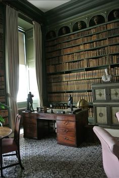 an old fashioned desk and chair in front of a bookshelf