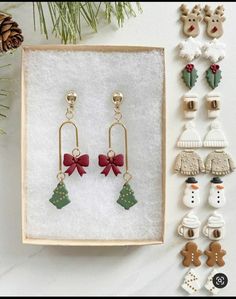 the earrings are on display next to other items in a wooden box and decorated with christmas decorations