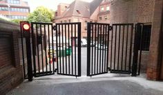 an open gate in front of a brick building