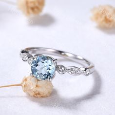 an engagement ring with a blue topaz surrounded by flowers