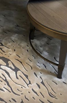 a close up of a coffee table with an animal print on the floor next to it