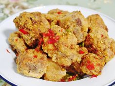 a white plate filled with fried food on top of a tablecloth covered table cloth