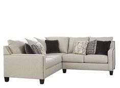 a sectional couch with pillows on it in front of a white background and black accents