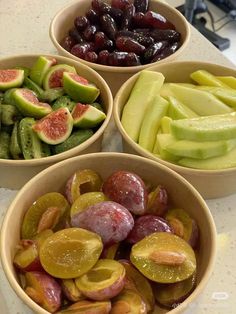 four bowls filled with different types of fruit