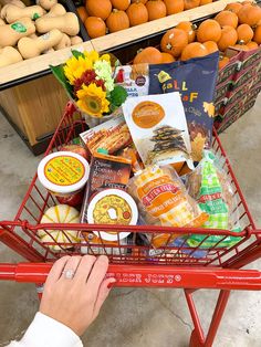 a person pushing a shopping cart filled with food