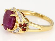 3.64ct oval ruby with .24ctw round Vermelho Garnet™ and .01ctw round white four diamond accent, 18k yellow gold over sterling silver ring. Measures approximately 0.69"L x 0.44"W. Not sizable. White rhodium Gold Ruby Jewelry With Pave Setting, Red Oval Jewelry With Pave Setting, Oval Red Jewelry With Pave Setting, Round Ruby Ring With Pave Setting For Gift, Oval Ruby Ring With Pave Setting, Oval Multi-stone Ruby Jewelry, Gold Oval Ruby Ring With Diamond Accents, Oval Ruby Ring With Gemstone Accents In Yellow Gold, Gold Ruby Ring With Gemstone Accents